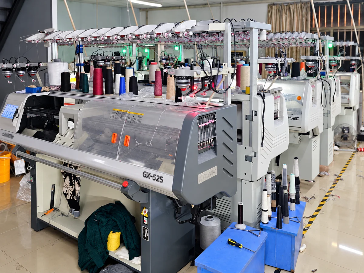 Computerized flat knitting machines with yarn feeds in a knitwear production workshop